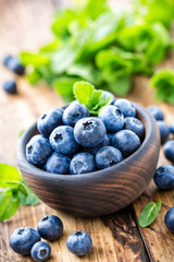 Fresh blueberries in bowl on wooden table