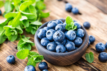 Fresh blueberries in bowl on wooden table