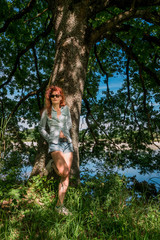 Femme contre le vieux chêne au bord de l'étang dans les Dombes