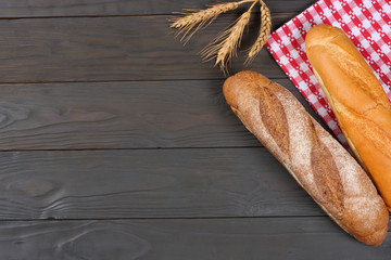 freshly baked bread on dark wooden background with red cloth. With copy space. Top view.