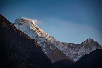 Scenic winter park in a snowy alpine landscape with mountains, peaks, and a sunset sky