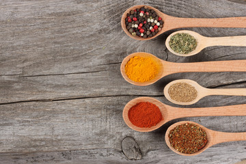spices in spoon on old wood background