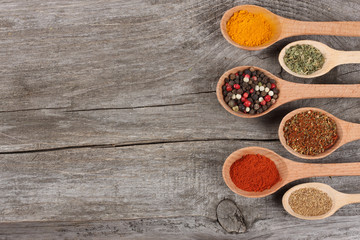 spices in spoon on old wood background
