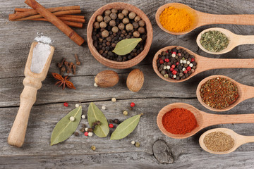spices in spoon on old wood background
