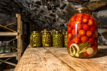 Preservation, pickles, marinades, in glass jars stand in the basement