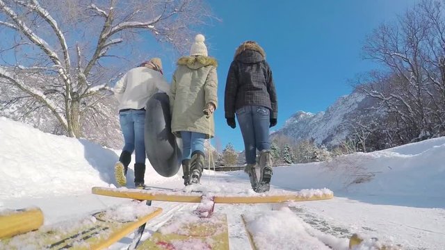 Gopro Footage (Perspective From Sled) Of Teens Walking Down Snow Covered Road With Sleds