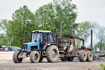 Fototapeta premium Tractor with trailer for transportation of logs