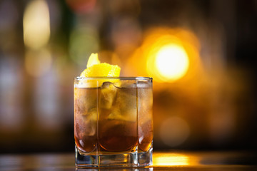 Closeup image of glass of long island cocktail at bright blurred background.