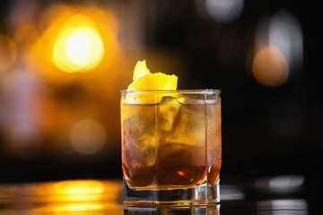 Closeup image of glass of cuba libre cocktail at bright blurred background.