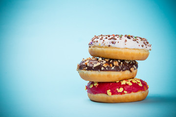 Donuts glazed with sprinkles on pastel blue background.