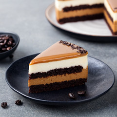 Caramel cake, mousse dessert on a plate. Grey stone background