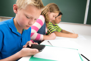 teenager mit dem handy im schulunterricht