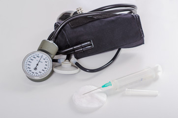 disposable syringe and a black stethoscope on a white background