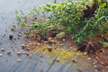 Mix of fresh thyme herbs and spices assortment on wooden background.