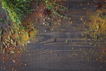 Mix of fresh thyme herbs and spices assortment on wooden background.