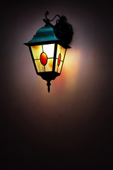Fototapeta na wymiar Glowing street lamp on the wall