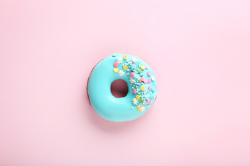 Tasty donut with sprinkles on paper background