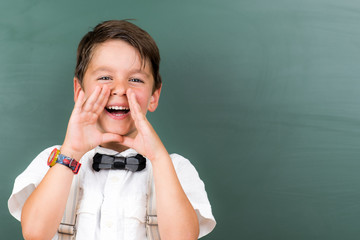 kind ruft in die schulklasse hände am mund