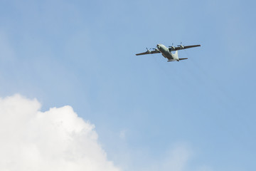 Fototapeta na wymiar Old Soviet military turboprop cargo plane flies over the city in the may 9 victory day