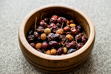 Dried Rosehips in wooden bowl. / kusburnu