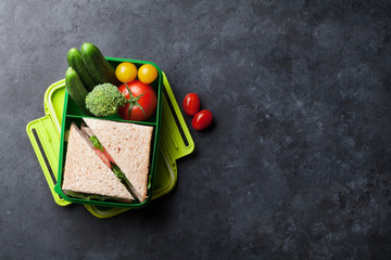 Lunch box with vegetables and sandwich