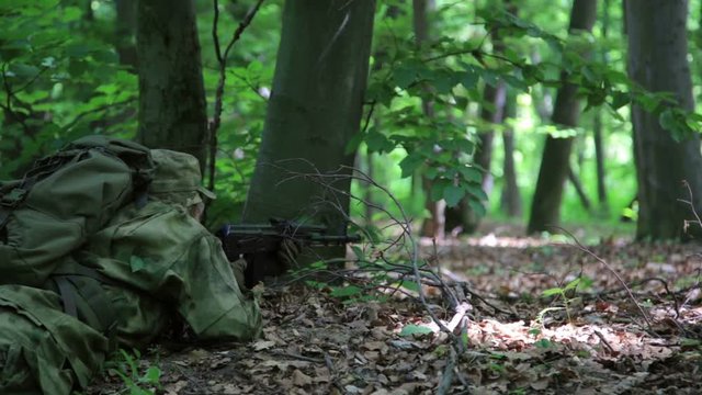 Guerilla partisan warrior sniper aiming in forest ambush carrying his gun. Partisan war reconstruction.
