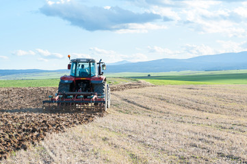 Obraz premium agricultural machinery working the land in the field.
