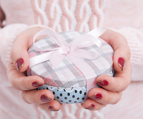 Woman's hands wrapping christmas, holiday handmade present in paper box with red ribbon. Give...