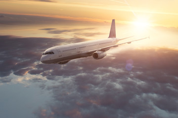 Fototapeta na wymiar Flugzeug fliegt bei Sonnenuntergang