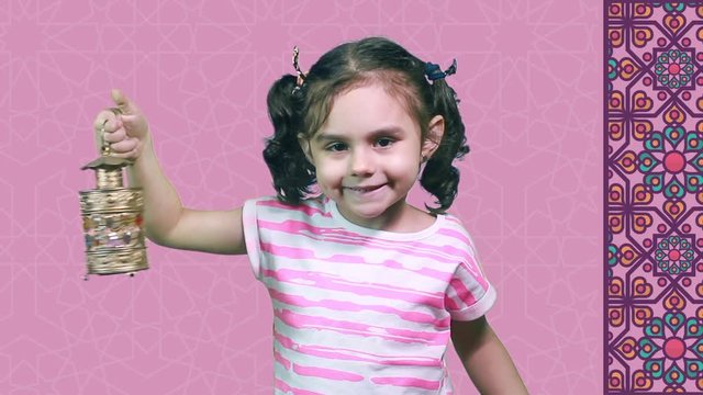 Happy Girl in Ramadan - Muslim girl celebrating Ramadan - playing with Ramadan lantern in front of Islamic background