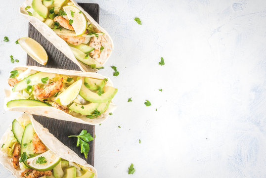 Healthy Food Snack. Tortillas Taco With Grilled Chicken, Avocado, Fresh Salsa, Lettuce, Lime. With Yogurt & Parsley Sauce. On Light Gray Stone Marble Table, Wooden Cutting Board. Copy Space Top View