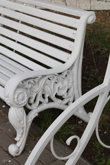 A fragment of a white bench in the park