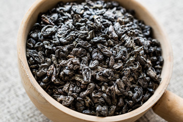 Dried Green Tea Bud in wooden ladle.
