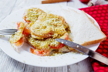Baked chicken chops with tomato, cheese, dill, greens, spices, garlic and white bread toast on a light wooden background 