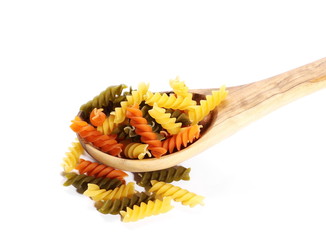 Colorful Italian spiral shaped pasta, macaroni in wooden spoon isolated on white background, top view