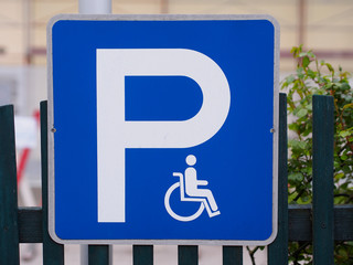 Blaues Verkehrsschild mit Rollstuhl
kennzeichnet Behindertenparkplatz