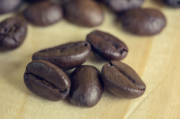 close up coffee beans on wooden background with effect filter.