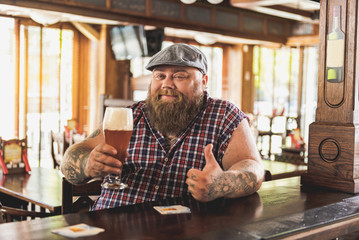 Cheerful bearded guy enjoying cold ale