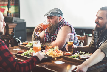 Three men drinking lager in pub