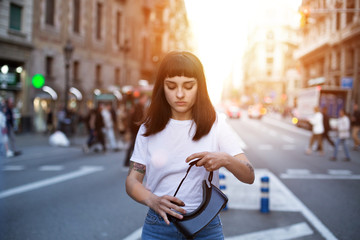 Petite cute girl stands in middle of street on a sunny summer evening learning how to use virtual reality futuristic technology glasses