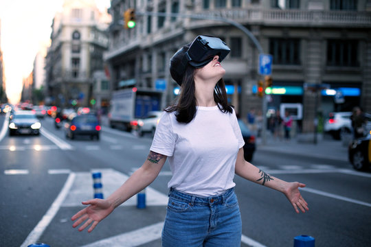 Beautiful young girl in the middle of a buzzling and busy city crossroad dives deep into the world