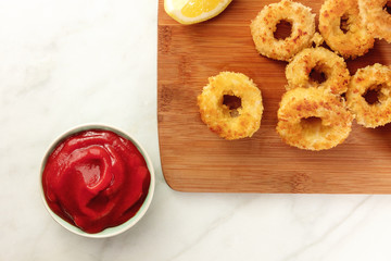 Calamari rings, red sauce, lemon, copyspace