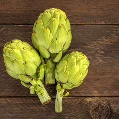 Artichokes on white marble texture with copyspace