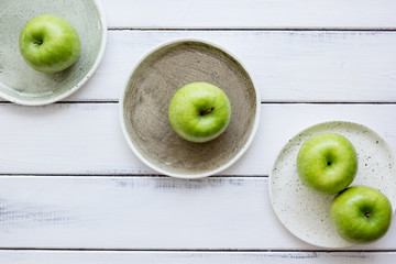 Healthy green food with apples on plates white background top view mock up