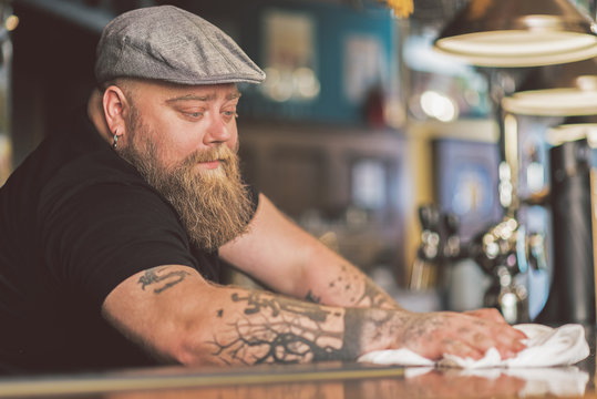 Bartender Wiping Down Countertop At Pub