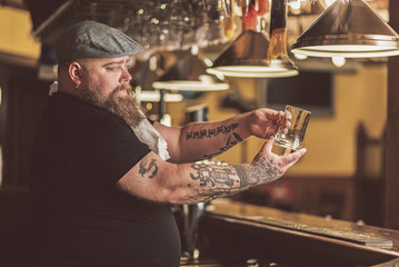 Tattooed guy waiting for first client in bar