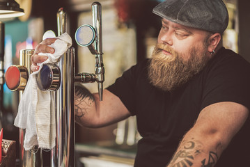 Bearded male working as bartender in pub