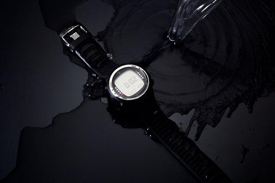Watches for scuba diving in streams of water on a black background, studio light
