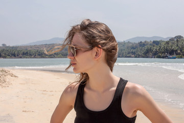 Fototapeta na wymiar girl with blowing hair on sand beach