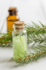 spa with organic spruce oil and sea salt in glass bottles on white table background